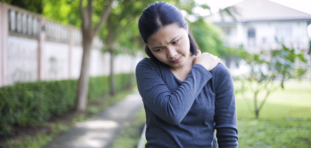 Woman gripping her shoulder in pain